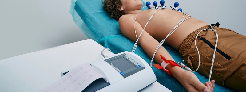 Ein Junge liegt auf einer Liege und bekommt ein EKG.